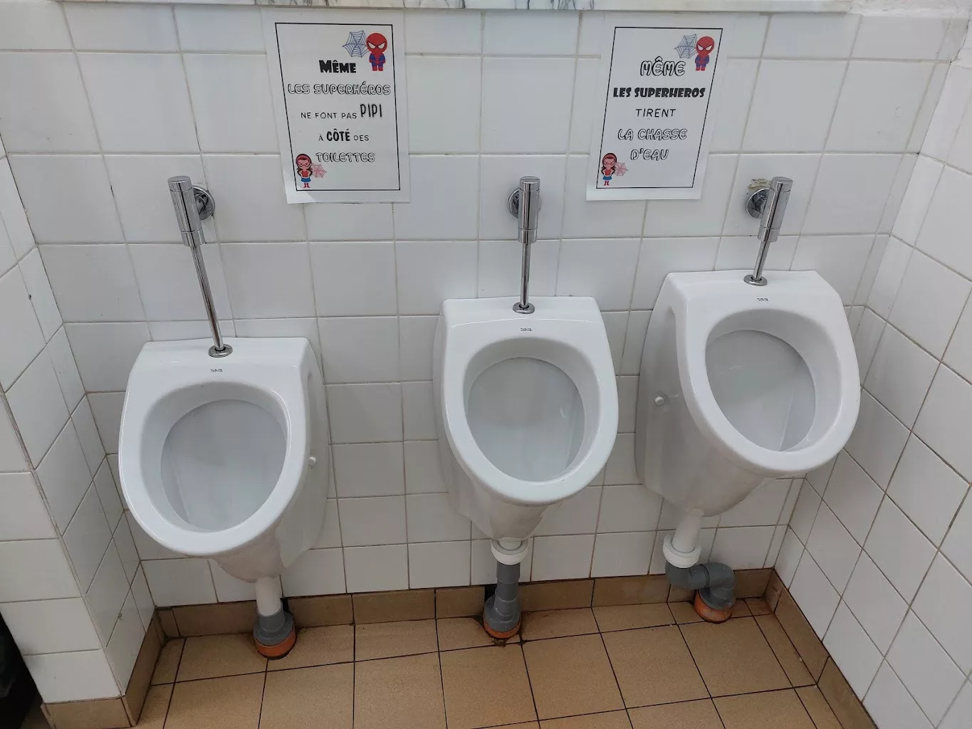Trois urinoirs suspendus avec chasses temporisées dans des sanitaires collectifs, réalisation YR Sanitaire & Chauffage à Péruwelz