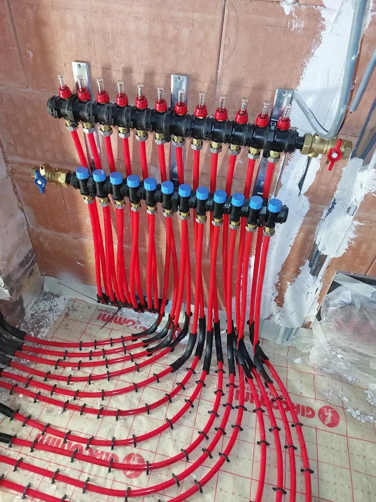 Collecteur de plancher chauffant à débitmètres raccordé aux circuits rouges, réalisation YR Sanitaire & Chauffage à Tournai